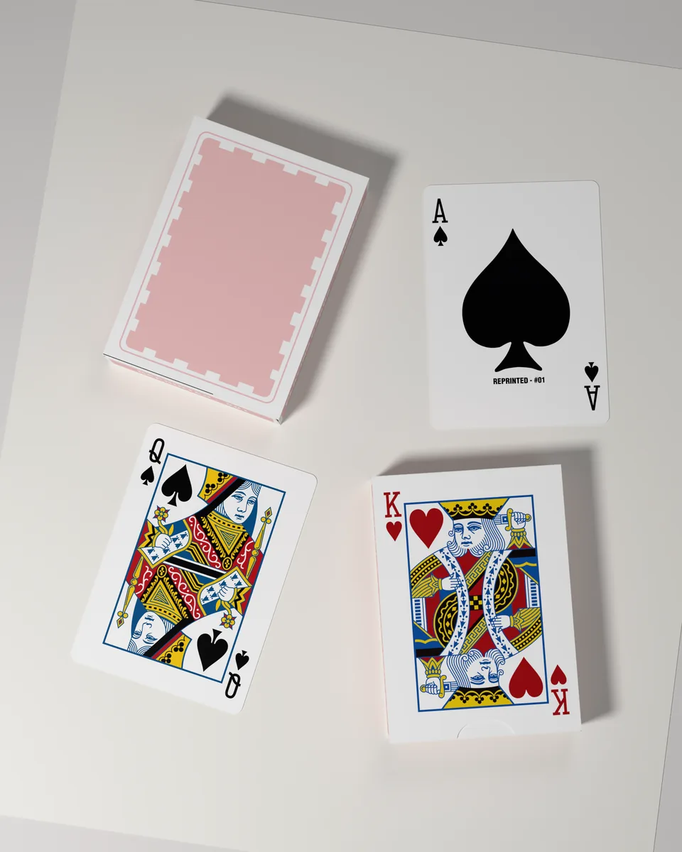 A REPRINTED #01 deck beside the ace of spades, the queen of spades and the king of hearts