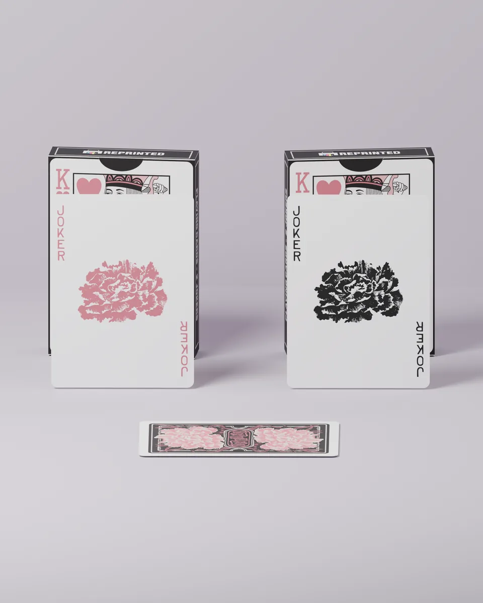 The pink and black jokers from REPRINTED #06 standing in front of their tuck cases